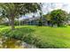 Spacious backyard with lush landscaping and tranquil water views from the screened lanai at 220 39Th Ne St, Bradenton, FL 34208