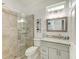 Neutral bathroom with shiplap detail, glass shower, updated lighting and vanity at 220 39Th Ne St, Bradenton, FL 34208