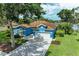 A stunning blue house with a well-manicured lawn and brick driveway, accented by lush landscaping at 220 39Th Ne St, Bradenton, FL 34208
