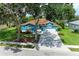 Charming blue home with a brick driveway and lush landscaping, framed by mature trees on a sunny day at 220 39Th Ne St, Bradenton, FL 34208