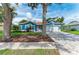Beautiful blue home with mature trees, well-kept lawn, and a brick driveway, exuding curb appeal at 220 39Th Ne St, Bradenton, FL 34208