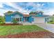 Beautiful blue home with a manicured lawn, brick driveway, and well-maintained landscaping at 220 39Th Ne St, Bradenton, FL 34208
