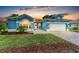 Charming blue home featuring a well-manicured lawn, beautiful brick driveway, and a welcoming front entrance at 220 39Th Ne St, Bradenton, FL 34208