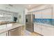Modern kitchen featuring stainless steel refrigerator, backsplash and white cabinets, with dining area views at 220 39Th Ne St, Bradenton, FL 34208