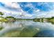 Scenic lake view with calm waters, reflecting the cloudy sky and surrounding homes and lush trees at 220 39Th Ne St, Bradenton, FL 34208