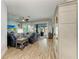 Bright living room featuring wood floors, ceiling fan, a sliding door leading to the outdoor pool and leather furniture at 220 39Th Ne St, Bradenton, FL 34208