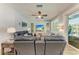 Cozy living room with wood floors, ceiling fan, large sliding glass doors to the pool, and comfortable leather sofas at 220 39Th Ne St, Bradenton, FL 34208