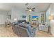 Bright living room with a leather sofa, ceiling fan, and large windows creating an inviting and comfortable space at 220 39Th Ne St, Bradenton, FL 34208