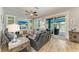 Bright living room with wood floors, ceiling fan, sliding door leading to the pool, and comfortable seating arrangement at 220 39Th Ne St, Bradenton, FL 34208