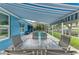 Outdoor dining area under a covered patio with a view of a screened pool and lake at 220 39Th Ne St, Bradenton, FL 34208