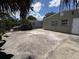 Backyard with large concrete pad surrounded by tropical foliage, fence and block outbuilding at 2629 14Th S Ave, St Petersburg, FL 33712