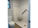 Bathroom shower featuring white tiling, a corner seat, and a grab bar at 3262 Brunswick Ln # 707, Sarasota, FL 34239