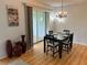 Cozy dining room featuring a chandelier, a dining table set for four, and view of enclosed lanai at 3262 Brunswick Ln # 707, Sarasota, FL 34239