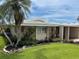Lovely single-story home featuring lush landscaping, a mature palm tree, and a well-maintained lawn at 3262 Brunswick Ln # 707, Sarasota, FL 34239