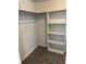 A carpeted walk-in closet features built in shelving for ample storage at 3262 Brunswick Ln # 707, Sarasota, FL 34239