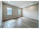 Sunlit bedroom features wood-look floors and two windows at 3512 Cross Creek Pkwy, Parrish, FL 34219