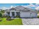 Charming one-story home with a tile roof, manicured lawn, paver driveway, and three car garage at 3512 Cross Creek Pkwy, Parrish, FL 34219
