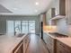 Modern kitchen featuring stainless steel appliances, a large island, and a view of the backyard through sliding glass doors at 3512 Cross Creek Pkwy, Parrish, FL 34219