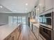 Modern kitchen featuring stainless steel appliances, a large island, and a view of the backyard through sliding glass doors at 3512 Cross Creek Pkwy, Parrish, FL 34219