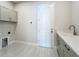 Well-lit laundry room features modern cabinets, sink, and hookups at 3512 Cross Creek Pkwy, Parrish, FL 34219