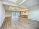 Open concept living room boasts wood flooring, modern lighting, and serene view of the backyard lake at 3512 Cross Creek Pkwy, Parrish, FL 34219