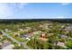 Residential area with a home surrounded by tall trees and a community in the distance at 3524 Brownwood Ter, North Port, FL 34286