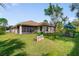 Landscaped backyard with a screened-in porch, table setting, and well-maintained lawn at 3524 Brownwood Ter, North Port, FL 34286