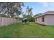 A fully fenced backyard with a patio and a mature tree providing shade at 3524 Brownwood Ter, North Port, FL 34286