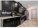 Modern kitchen featuring dark cabinets, sleek appliances, and stylish backsplash, with ample counter space at 3524 Brownwood Ter, North Port, FL 34286