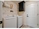 Bright laundry area with modern washer and dryer, storage cabinets, and tiled floor at 3524 Brownwood Ter, North Port, FL 34286