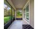 Enclosed porch featuring tile flooring, windows overlooking the garden, and an ottoman at 3524 Brownwood Ter, North Port, FL 34286