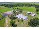 Aerial view of a sprawling white ranch home, barn, and surrounding pastures at 39700 State Road 70 E, Myakka City, FL 34251