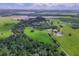 Expansive aerial view showcasing the acreage with mature trees, fields, and homes at 39700 State Road 70 E, Myakka City, FL 34251
