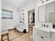 Bright bathroom featuring dual vanities, wood-look floors, and an open doorway to the bedroom at 39700 State Road 70 E, Myakka City, FL 34251