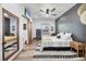 Bedroom with a modern aesthetic, featuring a bed, wood floors, a ceiling fan, and a barn door at 39700 State Road 70 E, Myakka City, FL 34251