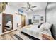 Bedroom with stylish decor, including a patterned rug, ceiling fan, wood floors, and a barn door at 39700 State Road 70 E, Myakka City, FL 34251