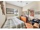 Modest bedroom with plaid bedding, tile floors, a ceiling fan, and lots of natural light from the window at 39700 State Road 70 E, Myakka City, FL 34251