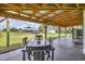 View of the farm from the covered patio featuring a table and chairs and an open beam ceiling at 39700 State Road 70 E, Myakka City, FL 34251