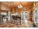 Dining area displaying a large table, wood paneling, tile floors, and access points to the outside at 39700 State Road 70 E, Myakka City, FL 34251