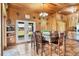 Dining area showcases wood paneling, tile floors, a chandelier, and a view of the outdoors at 39700 State Road 70 E, Myakka City, FL 34251