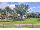View of the landscaped front yard and trees surrounding this white ranch style home at 39700 State Road 70 E, Myakka City, FL 34251