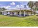 Side view of the house showing the generous covered outdoor living space with a patio at 39700 State Road 70 E, Myakka City, FL 34251