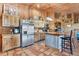 Country kitchen with stainless steel appliances, custom wood cabinets, and a corrugated metal island with bar seating at 39700 State Road 70 E, Myakka City, FL 34251