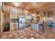 Rustic kitchen with stainless steel appliances, wood cabinets, tile floor, and a unique corrugated metal island at 39700 State Road 70 E, Myakka City, FL 34251