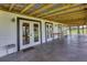 Large covered patio with a metal roof, offering picturesque backyard views and access through multiple French doors at 39700 State Road 70 E, Myakka City, FL 34251