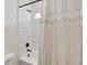 Bright bathroom featuring white subway tiles and modern black fixtures, accented by a decorative shower curtain at 39700 State Road 70 E, Myakka City, FL 34251