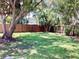Large backyard featuring a wooden fence and mature trees at 4112 Cochise Ter, Sarasota, FL 34233