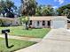 Inviting single-story home with a green lawn and mature trees; a welcoming exterior with a mailbox at 4112 Cochise Ter, Sarasota, FL 34233