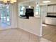 Well-lit kitchen with black appliances, white cabinets, and view of the dining room and lanai at 4112 Cochise Ter, Sarasota, FL 34233