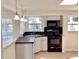 Well-equipped kitchen with black appliances, white cabinets, and a stylish countertop at 4112 Cochise Ter, Sarasota, FL 34233